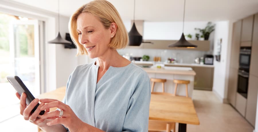 Resident holding a mobile device in a stylish home